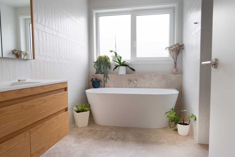 Bathroom featuring a freestanding bath and white uPVC window.