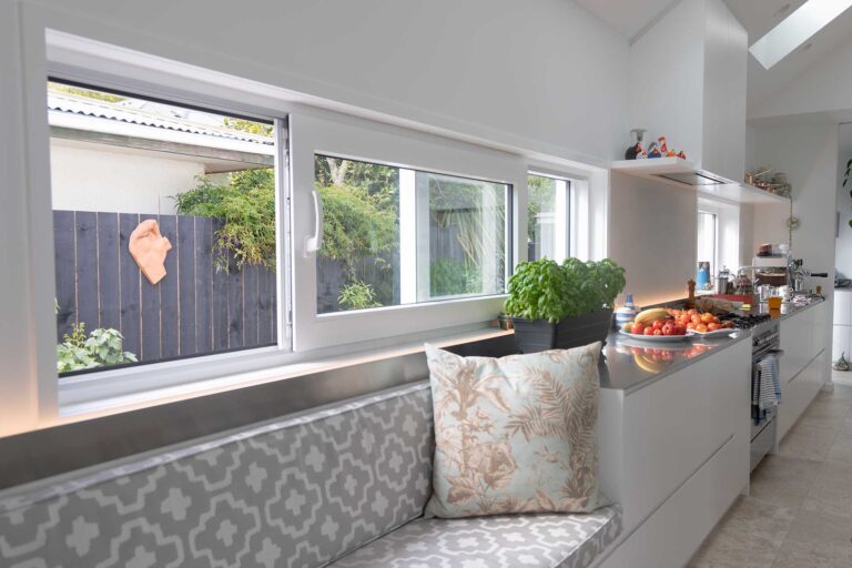 Kitchen window and built-in seating area featuring recessed white uPVC joinery.