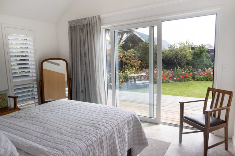 Bedroom with large white uPVC glazed doors opening toward the garden.