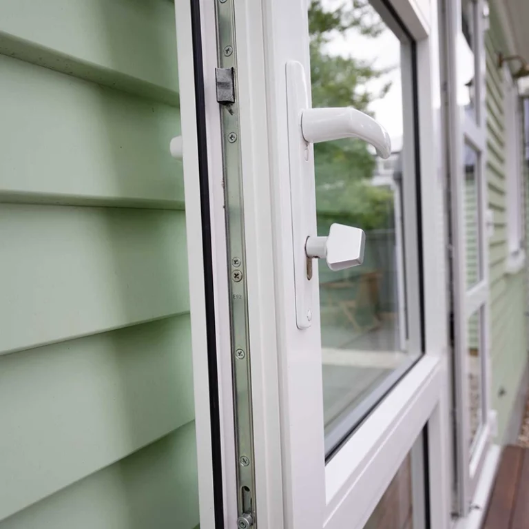 White casement window detail on green weatherboard exterior Beckenham Christchurch