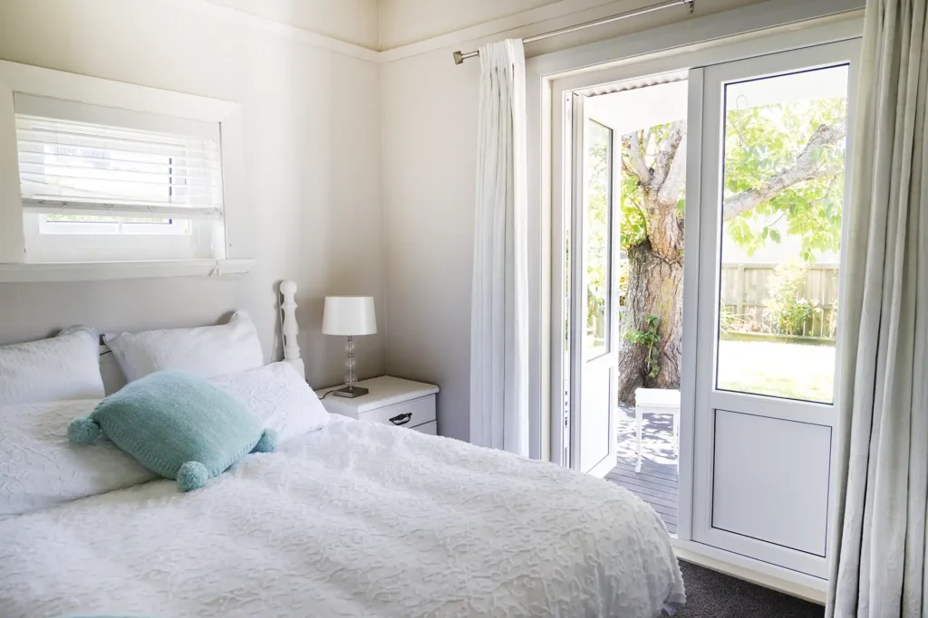 uPVC double glazed door from bedroom opening to garden with tree and outdoor space Christchurch