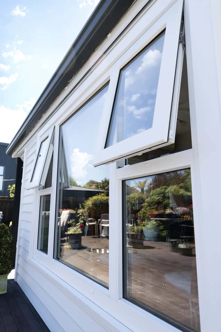 Exterior side view showing the newly installed white awning windows.