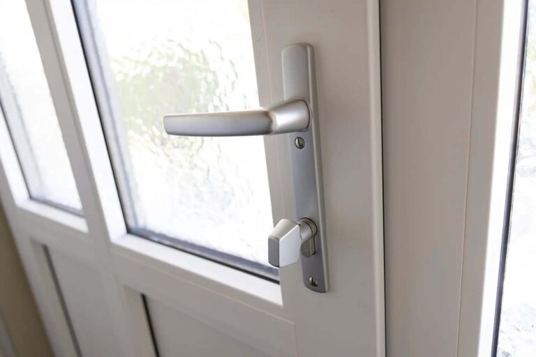 Close-up of the white uPVC door handle and locking hardware.